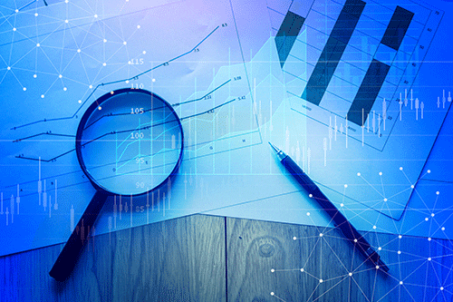 Picture of a desktop with paper graphs a magnifying glass and a pen.